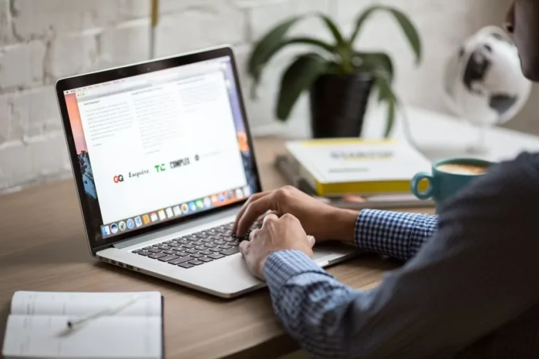 pessoa trabalhando com laptop em casa criando newsletter