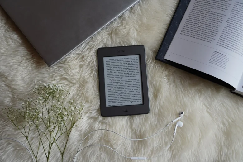 Leitor de e-books e livro sobre mesa, representando a autopublicacao na Amazon KDP como renda extra