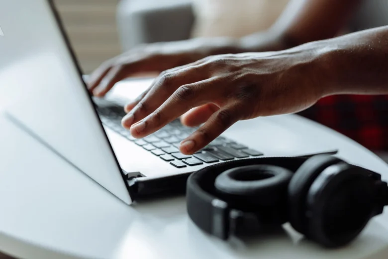 Pessoa trabalhando em transcrição de áudio no computador usando fones de ouvido