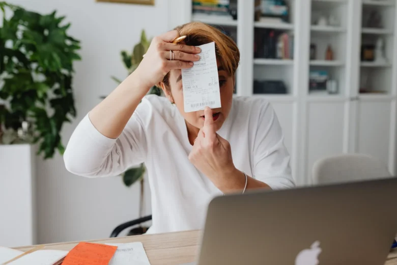 Pessoa trabalhando como freelancer em laptop, calculando taxas e ganhos líquidos.