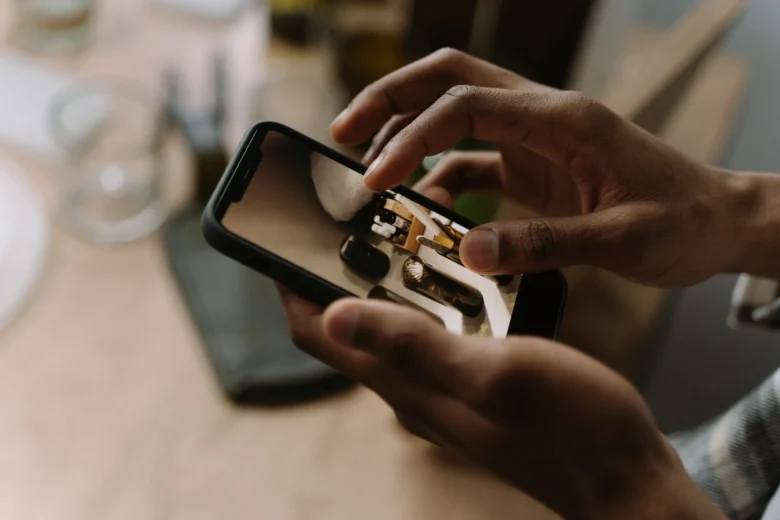 Pessoa segura o smartphone com um perfil de rede social aberto enquanto anota links de produtos em um caderno, trabalhando com afiliados sem site